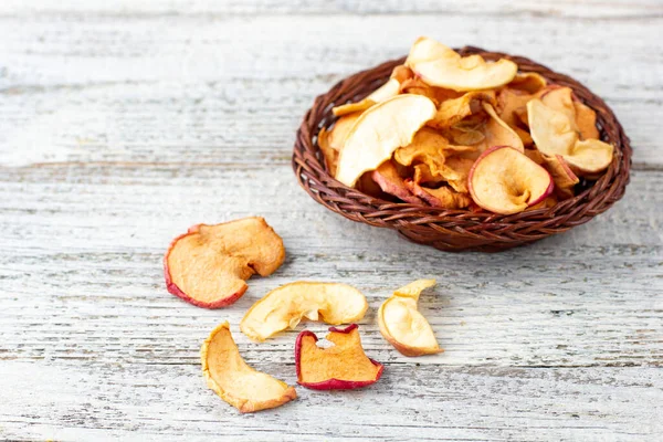 Ein Haufen Getrockneter Apfelscheiben Weidenkorb Auf Weißem Holzgrund Getrocknete Fruchtchips — Stockfoto