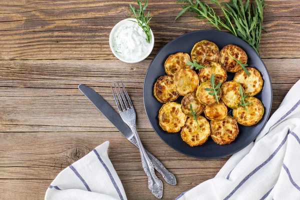 Ekşi krema soslu kızarmış kabak dilimleri. Doğal kahverengi ahşap arka planda akşam yemeği için otlu kızarmış kabaklar. Kopyalama alanı olan üst wiev