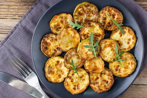 Ekşi krema soslu kızarmış kabak dilimleri. Doğal kahverengi ahşap arka planda akşam yemeği için otlu kızarmış kabaklar. Üst Wiev