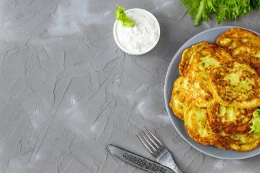 Ekşi krema soslu ve yeşillikli kabaklı börekler. Gri arka planda yeşil salatalı sebzeli gözleme. Kopyalama alanı olan üst görünüm