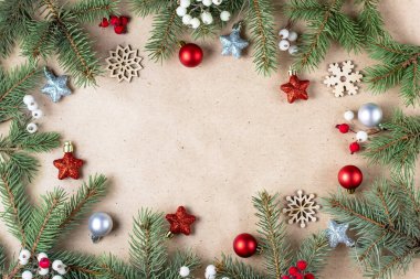 Gümüş ve kırmızı süslemeli köknar ağacı çerçevesi. El işi kağıdında noel kartı ve metin için fotokopi alanı var. Mutlu yıllar konsepti. Tatil geçmişi. Noel maketi. Üst manzara, düz uzanma