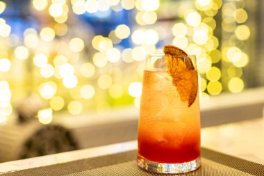 Pencerede greyfurtla süslenmiş, altın sarısı bir şarap kadehi..