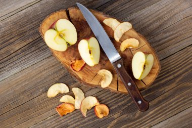 Ahşap zemin üzerinde kurumuş elma ve taze olgun elmalar yığını. Kurutulmuş meyve cipsi. Sağlıklı vejetaryen yemekleri