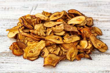 Beyaz ahşap arka planda dilimlenmiş kuru armut yığını. Kurutulmuş meyve cipsi. Sağlıklı yemek.