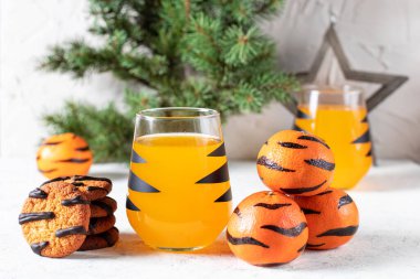 Siyah çizgili ve kurabiyeli, camlı turuncu mandalina kokteyli. Noel tatili içkisi. Çocuklar için ağaç dalları olan yeni yıl kavramı