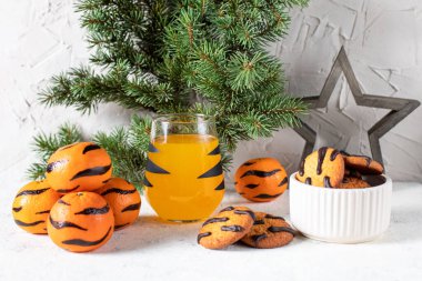 Siyah çizgili ve kurabiyeli, camlı turuncu mandalina kokteyli. Noel tatili içkisi. Çocuklar için ağaç dalları olan yeni yıl kavramı