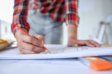 İnşaat alanında yalnız çalışan bir mühendis. Ana planın taslağı üzerine proje ile birlikte mimari.