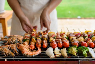 Izgara ve Barbekü partisi evde. Domuz eti, sığır eti, tavuk, deniz ürünleri ve sebze pişiriyorum. Aile hayatı ve açık hava aktiviteleri..