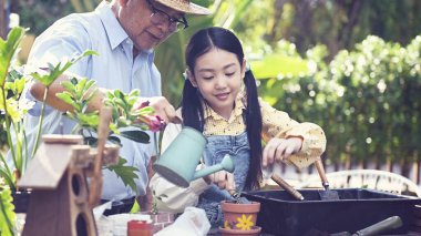 Dedem ve torunum bahçeye ağaç dikiyorlar. Yaz tatilinde ailesiyle birlikte emeklilik hayatı..