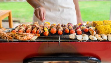 Izgara ve Barbekü partisi evde. Domuz eti, sığır eti, tavuk, deniz ürünleri ve sebze pişiriyorum. Aile hayatı ve açık hava aktiviteleri..
