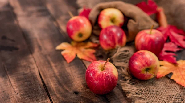 木製の箱に有機熟した赤いリンゴ 秋にはトウモロコシの収穫があります 木のテーブルの背景を持つ新鮮な果物 — ストック写真