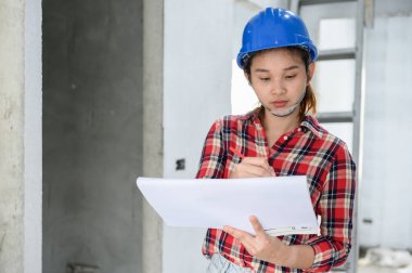 İnşaat alanında yalnız çalışan bir mühendis. Ana planın taslağı üzerine proje ile birlikte mimari.