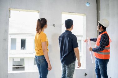 Mühendis ve mimarla birlikte yeni ev teftişinin sahibi. Köy projesinde ve emlak binasında aşk çifti.