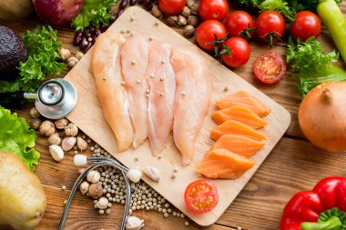 Salata pişirmek için taze somon balığı ve sebzeli tavuk. Sağlıklı ve diyet yemekleri.