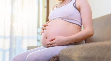 Hamile kadın evde yalnız kalır. Anne ve yeni doğmuş bebek. Anneler Günü ve Uluslararası Kadınlar Günü.