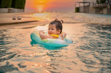 Çocuk yaz tatilinde yüzme havuzunda yüzer. Asyalı küçük kız yaşam tarzı ve rahatlatıcı.