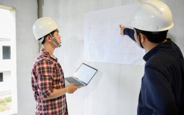 Mühendis ekibi inşaat sahasında tartışıp çalışıyor. Köy projesi ve emlak binasında teftiş.