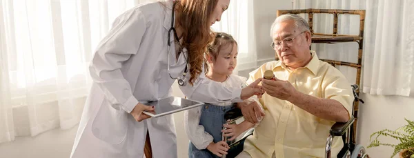 Asyalı son sınıf öğrencisi hastaydı ve tekerlekli sandalyede oturuyordu. Doktor evde emeklilik yaşını kontrol ediyor..