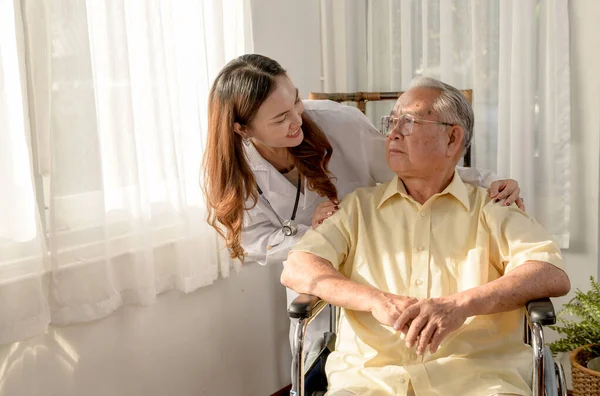 Asian Senior man was sick and sitting on wheelchair. The doctor check retirement age health at home.