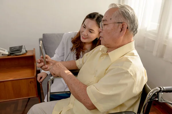 アジア系の老人は病気で車椅子に座っていた 医者は家で定年をチェックする — ストック写真