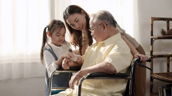 アジア系の老人は病気で車椅子に座っていた 退職年齢のライフスタイルと家庭で家族と一緒に ストック写真