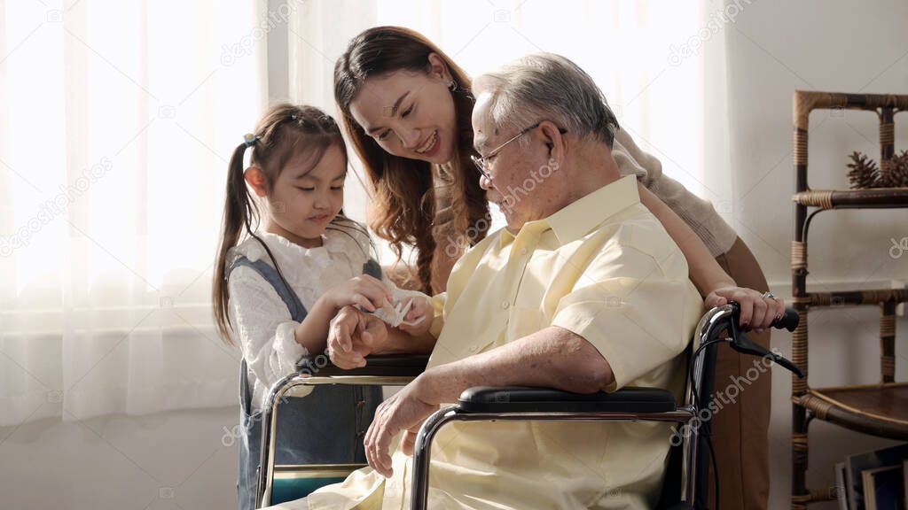 Asian Senior man was sick and sitting on wheelchair. Retirement age lifestyle and togetherness with family at home.