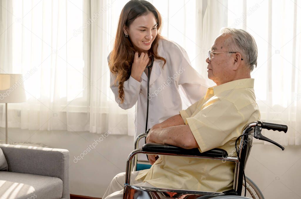Asian Senior man was sick and sitting on wheelchair. The doctor check retirement age health at home.