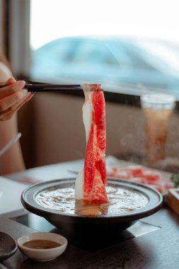 Shabu-shabu çorbasına batırılmış et (sığır eti) yakın çekim