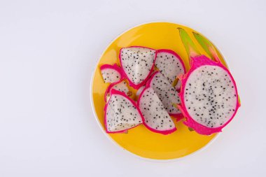 Beyaz arka planda izole edilmiş tabakta ejderha meyvesi