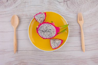 Tahta arka planda ejderha meyvesi ve tahta kaşık 