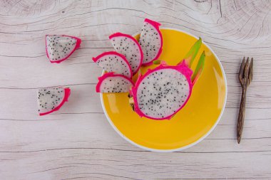 Tahta arka planda ejderha meyvesi ve tahta kaşık 