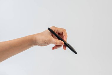 Beyaz arka plana karşı elinde siyah bir kalem.