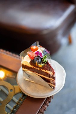 Limonata ile kaplanmış güzel bir yaban mersinli kek tabakta servis edilir, arkaplan olarak da kafe..