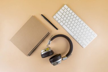 Defter masanın üstünde. Mesaj bırakmak için boş bir defter. Kalemler, kulaklıklar