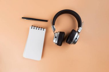 Defter masanın üstünde. Mesaj bırakmak için boş bir defter. Kalemler, kulaklıklar