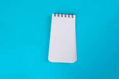 Mavi arkaplanda beyaz bir defter.