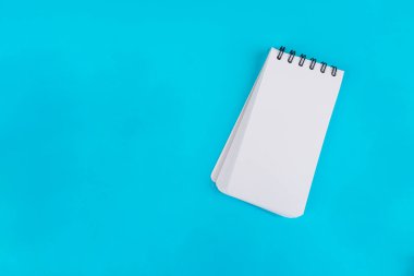 Mavi arkaplanda beyaz bir defter.