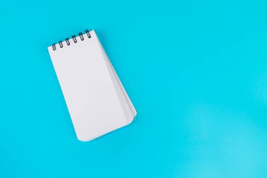 Mavi arkaplanda beyaz bir defter.