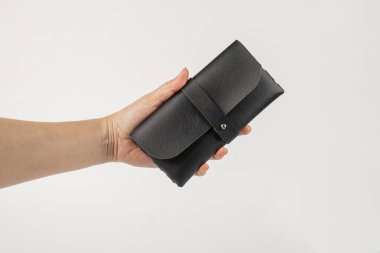 Beyaz bir arka planda, elinde siyah bir gözlük kılıfı..