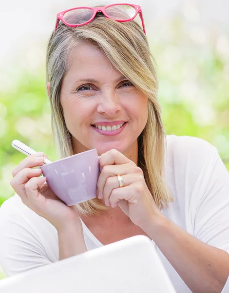 Pause café de belle blonde mature travaillant à la maison dans son jardin — Photo