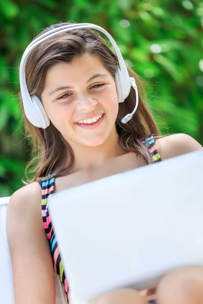Щасливий підліток з ноутбуком і навушниками в дивані — стокове фото