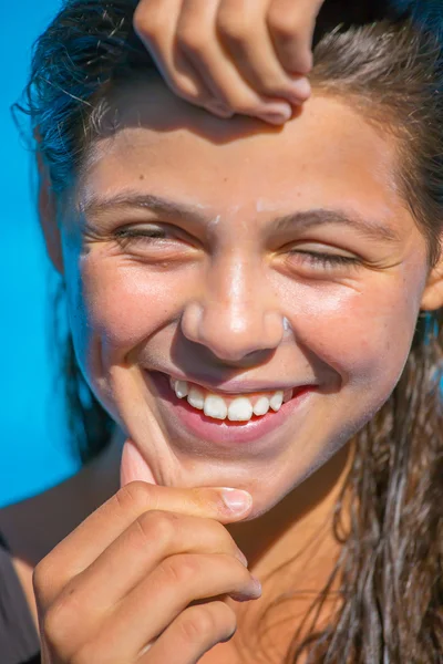 Защитите солнцезащитный крем, нанесенный на лицо улыбающейся девушки — стоковое фото