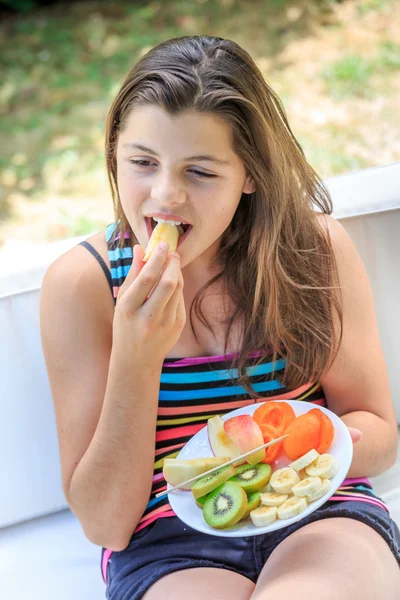 Krásné dospívající s barevné oblečení, jíst čerstvé ovoce v g — Stock fotografie