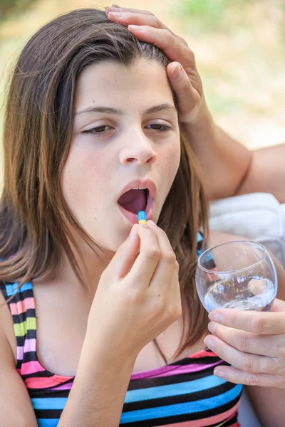 Detailní záběr na mladé dívky, které medicína pilulka s vodním sklem — Stock fotografie