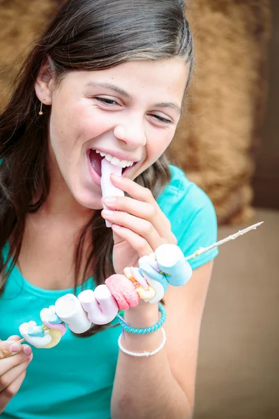 Közelkép a csinos, fiatal lány, enni egy finom marshmallow nyárs — Stock Fotó