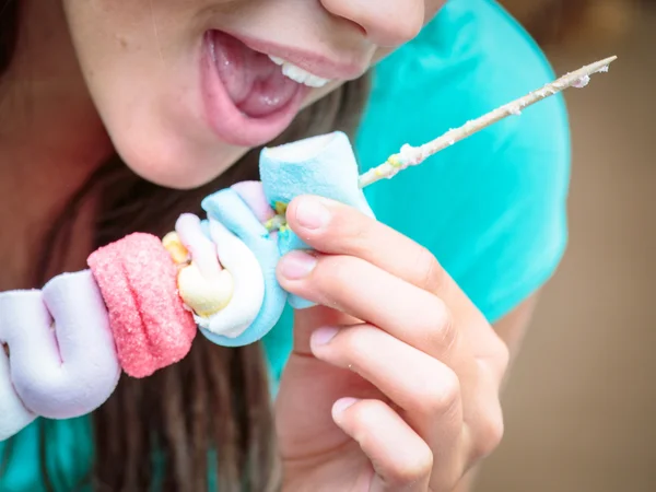 Detailní záběr na pěknou mladou dívku jíst chutné marshmallow špíz — Stock fotografie