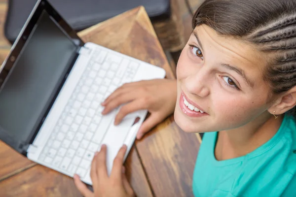 Крупним планом красива молода дівчина посміхається, хто друкує на клавіатурі комп'ютера, видно зверху — стокове фото