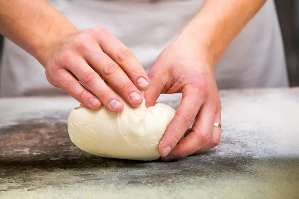 Primer plano de la mano de un panadero amasar y dar forma a la masa — Foto de Stock