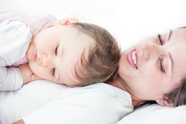 Bebeğini beyaz arka plan üzerinde gülümseyen bir genç kadınla Close-Up