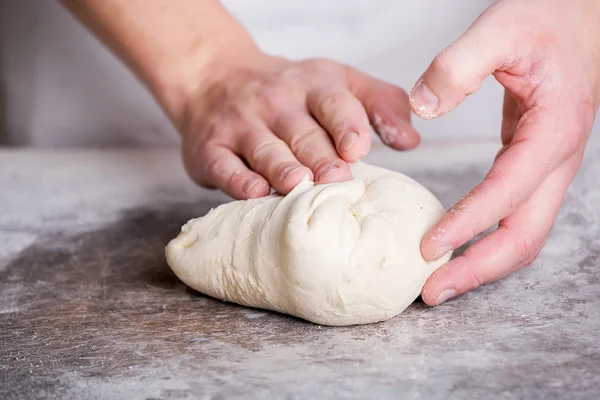 Primer plano de la mano de un panadero amasar y dar forma a la masa — Foto de Stock